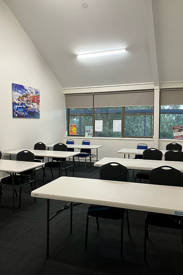 Well-lit classroom set up with tables and chairs