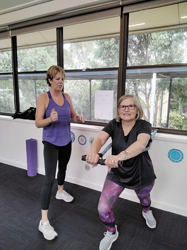 Woman being encouraged by instructor in Strong People Stay Young fitness class