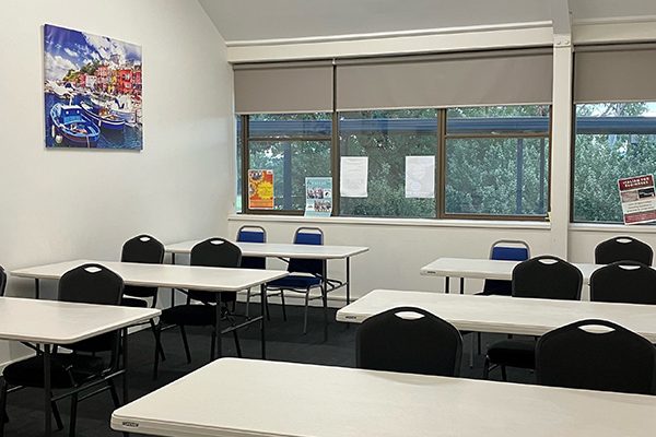 Well-lit classroom set up with tables and chairs