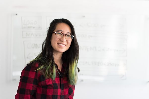 Aged care student standing in front of whiteboard smiling